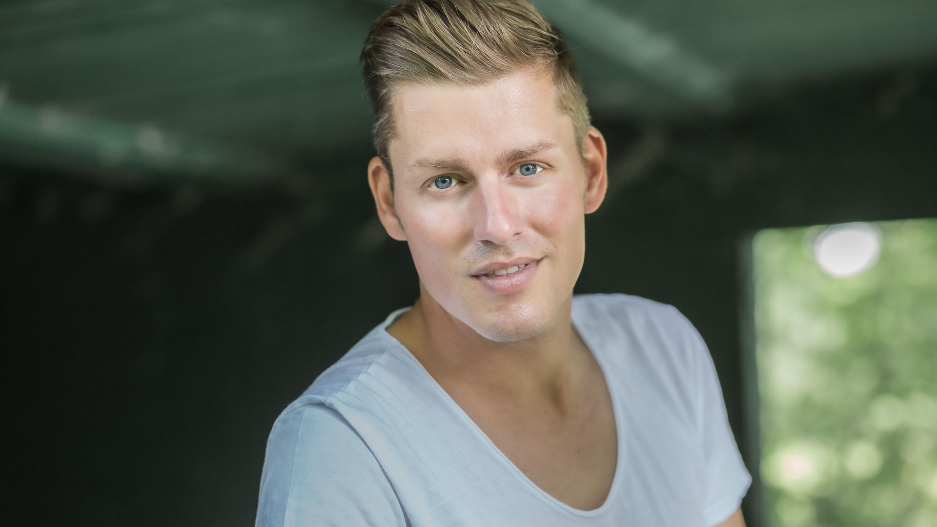 Online-Dating-Fotos: Profilfoto eines jungen, blonden Mannes mit blauen Augen, der sypathisch in die Kamera lächelt.