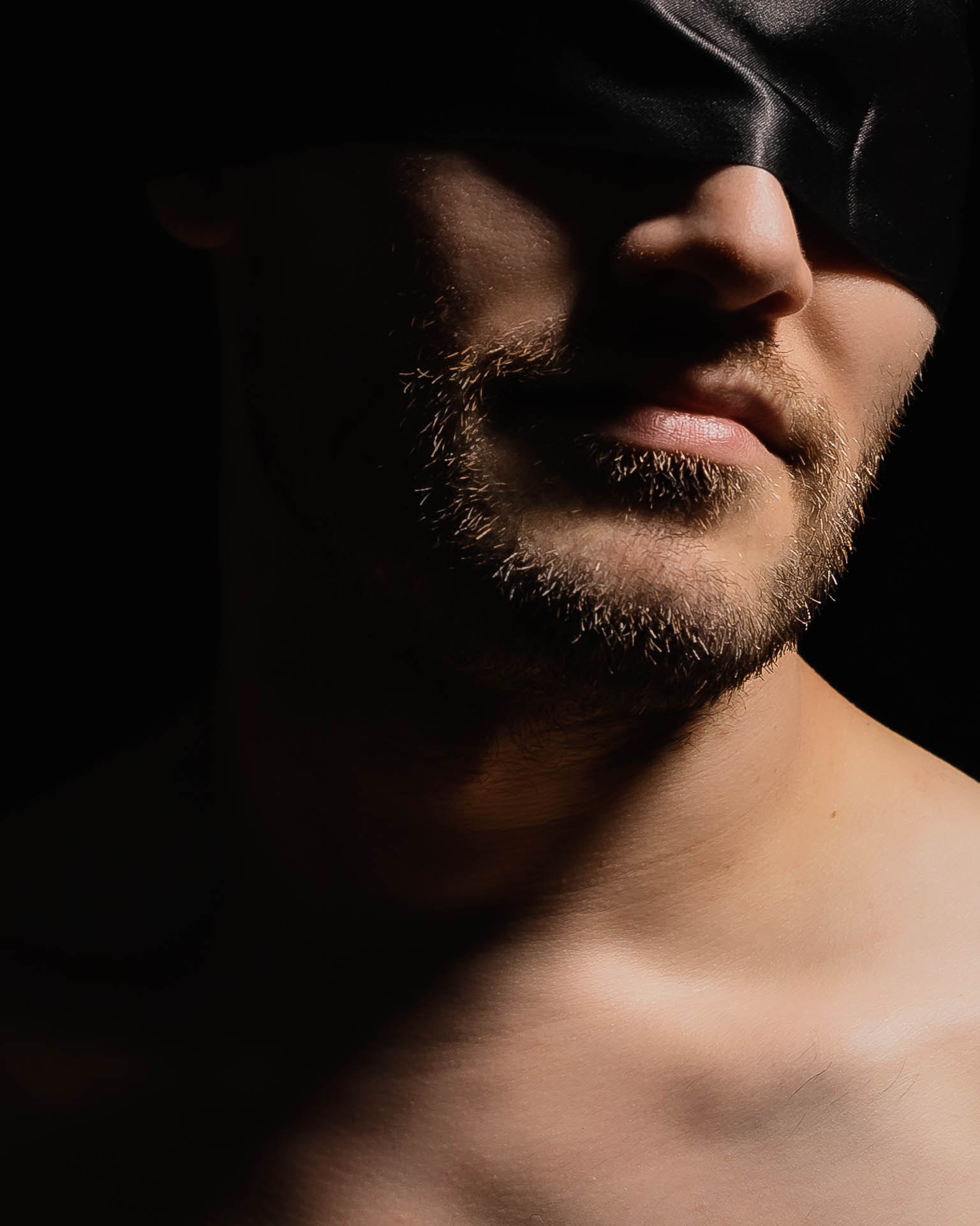 Ein Bodypart-Foto: Mann mit Bart und Augenbinde, close-up